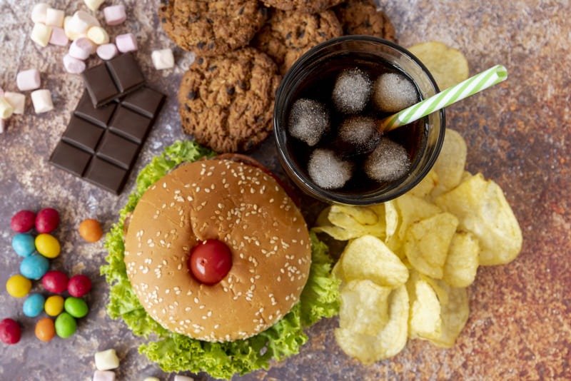 Mesa repleta de ultraprocessados, alimentos que devemos evitar.